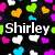 Pixelated icon with black background featuring scattered heart shapes in pink, yellow, green, blue, and white, with the name "Shirley" in white pixelated text centered below.