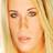 Pixelated close-up of a person's face with light brown hair and warm-toned skin, rendered in low-resolution 256x256 pixels.