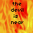 The devil is near text in pixelated font over a fiery background with orange and yellow flames, displayed across multiple