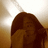 A pixelated image shows a figure with long brown hair covering their face, set against a gradient background transitioning from light to dark tones.