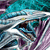 A dynamic abstract composition of flowing metallic ribbons in teal, silver, and purple hues with subtle motion blur effects.