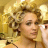 Static 48x48 pixel icon showing a close-up of a person with curly hair against a golden-yellow background, rendered in low-resolution pixel art style with visible dithering and color blending.