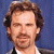A pixelated image of a person with brown hair and facial hair against a blue background, next to green text reading 'Original Icons .com' on dark green.