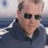 A four- with a pixelated image of a man in sunglasses and a dark jacket on the top-left, and three text on the top-right, bottom-left, and bottom-right