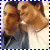 Two side-by-side figures in a pixelated style, one with dark hair and light shirt, the other with lighter hair and darker shirt, both smiling against a blue checkered border.