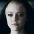 Pixelated close-up of a person's face with closed eyes, dark hair, and a neutral expression against a dark background.