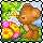 Pixelated cartoon icon of a brown monkey sitting on grass with flowers and trees in the background.