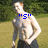 A shirtless man with light hair stands outdoors on grass, wearing dark shorts; blue pixelated text changes across frames.
