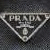 Two identical triangular icons with 'PRADA' text and a central emblem on dark textured background, each featuring subtle animation.