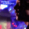 Animated sequence showing a person's face in profile and front view with blue lighting effects, text overlays reading 'IN THE SORROW' and 'OF THE NIGHT', and red dots on the lower left.