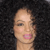 Pixelated close-up of a person's face with light skin, dark eyes, and pink lips against a dark background.