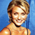 Pixelated image of a person with short light brown hair, smiling, wearing a sleeveless top against a blue background.
