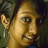 Pixelated close-up of a person's face with light skin tone, dark hair, and visible ear, set against a dark green background.