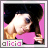 Pixelated image of a person with dark hair covering one eye, wearing a pink top and brown patterned sleeves, against a pink background with 'alicia' text below.