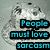 Pixelated grayscale cartoon character with large eyes and a rounded head, overlaid with cyan text blocks on black backgrounds.