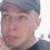 Pixelated close-up of a person's face with short dark hair, light skin, and visible facial features including eyes, nose, and mouth.