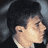 Pixelated static image of a person with dark hair and light skin in close-up, likely from a movie or TV show scene.