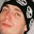 Pixelated close-up of a person's face with dark hair and a black-and-white checkered pattern on the right side.