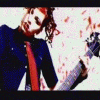 Animated sequence of a person with long curly hair playing electric guitar, wearing dark blue shirt and red tie against white background with scattered red specks.