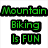 Green pixelated text reads 'Mountain Biking Is FUN' on left, white block letters spell 'TRY IT!' in black rectangular frames on right.