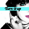 Black-and-white close-up of a person with dark hair holding a phone to their ear, overlaid with a cyan banner reading 'Turn it up' in black script.