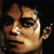 Pixelated static image of a person's face with warm brown and orange tones against dark background, showing partial facial features including eyes, nose, mouth, and ear.