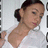 A person in a white top with dark hair tied back, shown in four with slight head and eye position changes