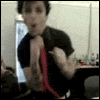 A person in a black shirt with a red tie performs a sequence of hand movements against a blurred background with visible bottles and a red sign.