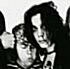 Black-and-white animated sequence showing a person with long dark hair performing repeated head movements and hand gestures in front of a blurred background.
