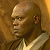 Pixelated static image of a bald man's profile with brown skin tone, wearing light-colored clothing against warm-toned background.