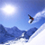 Pixelated static image of a skier mid-air against a blue sky with snow-covered mountains and sun glare, rendered in low-resolution 256x256 pixels.