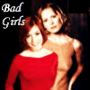Two women pose together in a of ; one wears a red off-shoulder top, the other a light brown sleeveless top, with "Bad Girls" text in the top-left corner