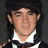 Pixelated image of a person with long dark hair wearing a dark cap and white-collared shirt, next to green text reading 'Paul Kevin Jonas II' and a heart symbol.