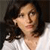Pixelated close-up of a person with dark hair wearing a white top, looking slightly upward and to the left.