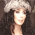 A pixelated static image shows a person with long dark hair wearing a light-colored beret, set against a dark background.