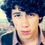 A person with dark curly hair wearing a light-colored collared shirt under a dark jacket appears in three distinct poses across the