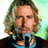 six with a person holding a microphone against a light green background, featuring yellow pixelated text reading "this is the face of an ANGEL!!"