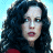 Pixelated close-up of a person with long dark hair against a light blue background, wearing a red garment at the bottom edge.