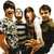Four people pose together in a group photo with one person holding another, while text appears on the right side of the image.
