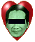 Two side-by-side pixelated images of a green-skinned figure with blacked-out eyes, one framed by red heart shape and the other by white outline.