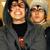 Pixelated static image of two people in close proximity with warm lighting and dark clothing against a blurred background.