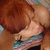 A pixelated anime-style character with brown hair and a striped top, shown in a close-up pose with eyes closed and a hand near the face.