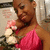 A person in a pink halter dress holds three ice cream scoops, with background text partially visible.