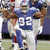 A football player in a blue and white uniform with the number 92, captured across showing slight movement