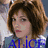 A pixelated image of a person with short brown hair and red lips, wearing a blue top with white accents.
