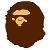 Brown rounded shape with light beige facial features including eyes and mouth on a white background.