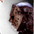 Pixelated static image of a character's face with brown hair and dark clothing against a light background, likely from a horror movie franchise.