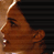 Pixelated close-up of a brown cartoon character's face with visible anti-aliasing and dithering, showing partial facial features against dark horizontal stripes.