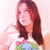 A person with long brown hair wearing a white shirt featuring a colorful graphic, shown in four with subtle pose changes