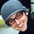 A pixelated image shows a person wearing a blue beanie and light-colored clothing, with large white letters L and 9 on the right side.
